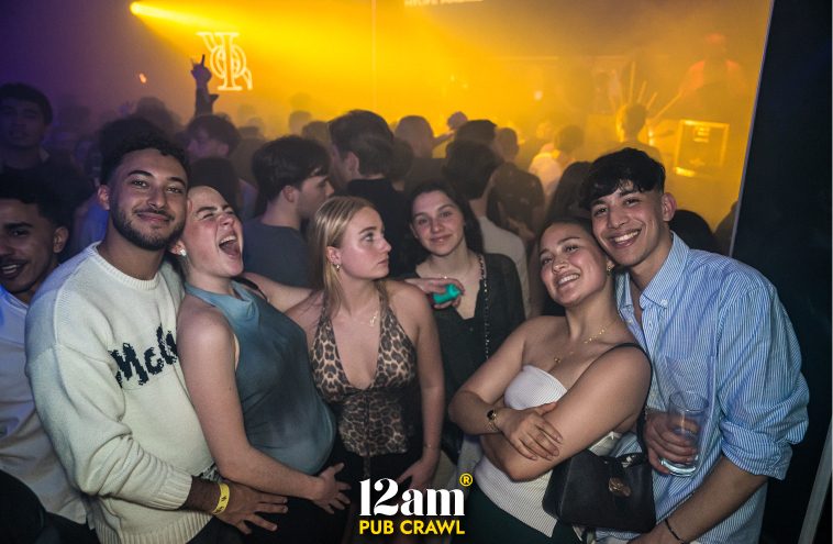 Diverse group of happy young adults, including Erasmus students and solo travelers, enjoying an Arabian night themed event at ICON Madrid Club during a 12am Pub Crawl. Showcasing unique Madrid nightlife experiences.