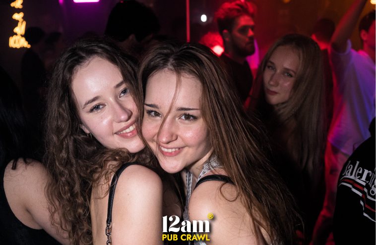 Young adults, including Erasmus students and solo travelers, dancing and enjoying the electrifying atmosphere inside ICON Madrid Club during a 12am Pub Crawl. Experience the best of Madrid's clubbing scene.